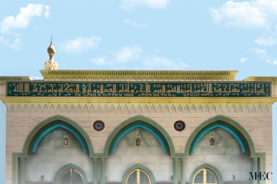 Exterior arches of a mosque cladded with glass mosaic tile patterns with aqua and green palette. Handcrafted calligraphy mosaic with 24k gold foiled tiles.
