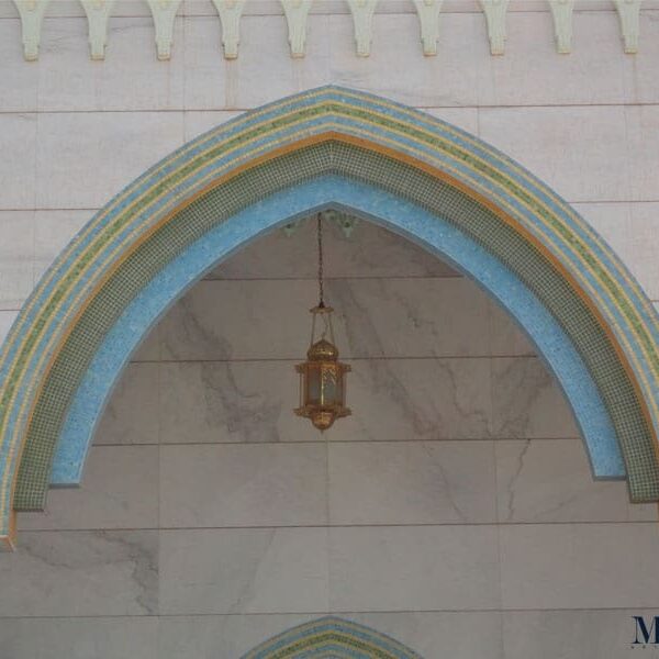 Exterior arches of a mosque cladded with intricately placed glass mosaic tile patterns in a calming aqua and green palette. Custom handcrafted by MEC.
