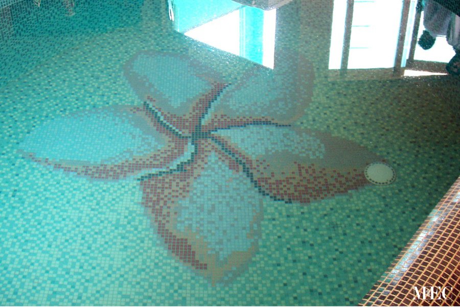 Custom Mosaics by MEC | Plumeria flower pattern with a five petal flower crafted out of glass mosaic for the swimming pool.