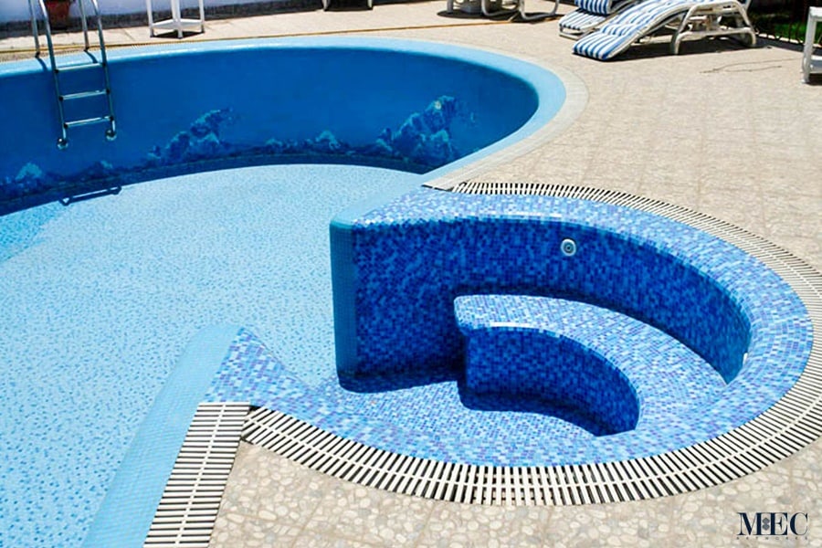 Custom Mosaics by MEC | Mosaic swimming pool featuring a combo of ocean waves design and a lively blue mosaic tile random color mix.