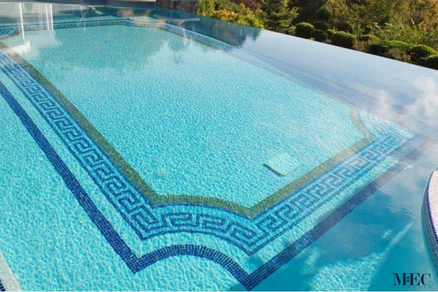 Custom Mosaics by MEC | Greek square pool featuring a multi-line border in blue and yellow paired with a light blue random mixing glass mosaic.