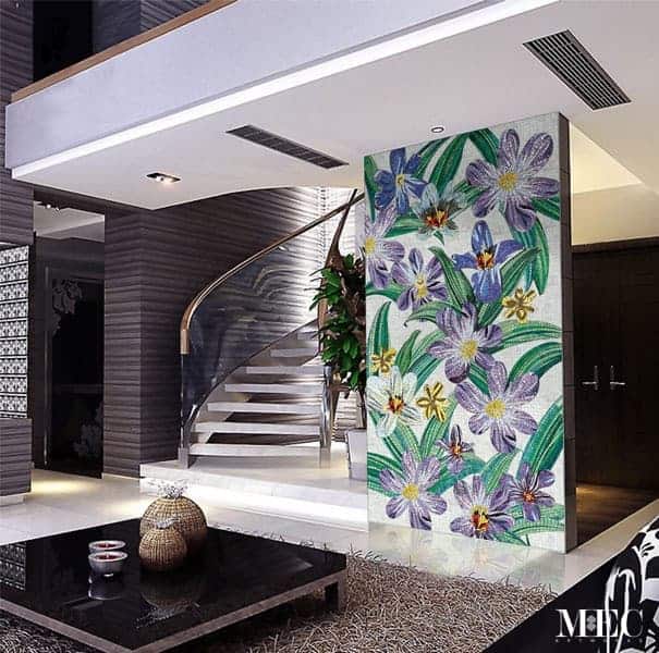 Mosaic flower art on the wall beside a staircase in an elegant interior.