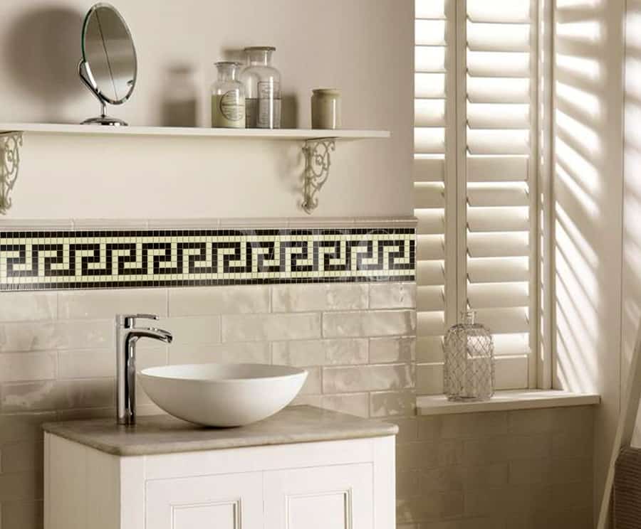 bathroom wall clad with mosaic borders tiles featuring a Greek Key pattern