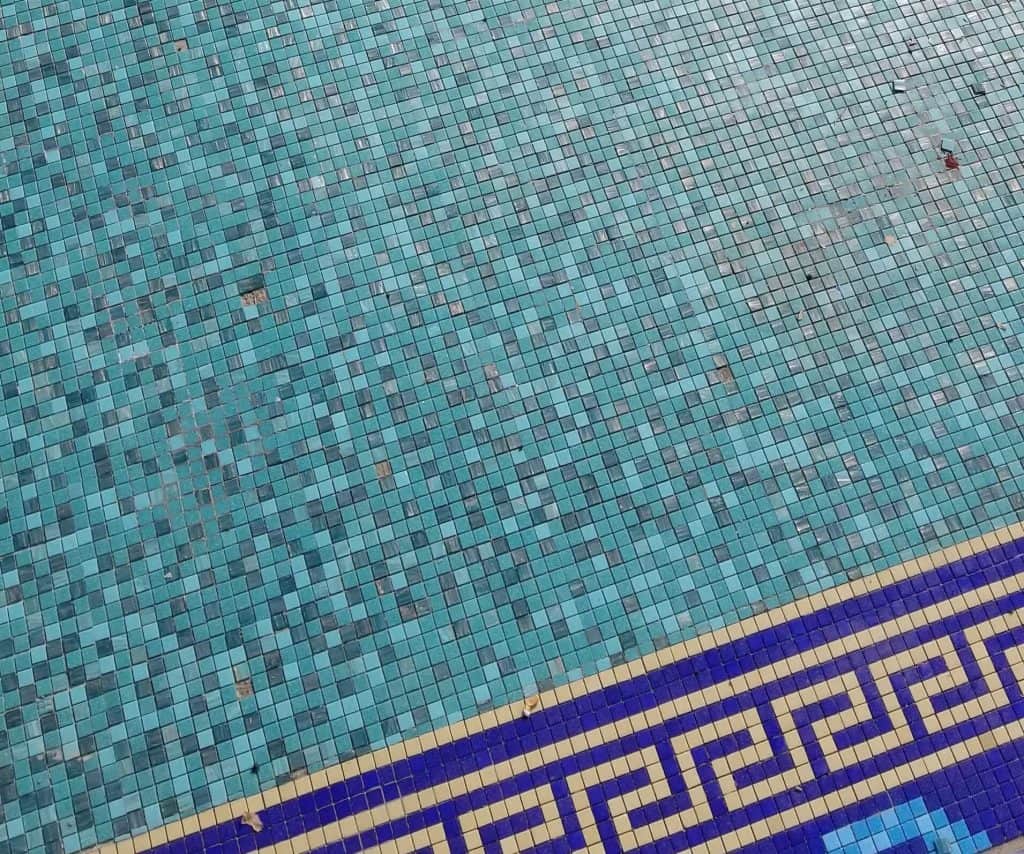 glass mosaic swimming pool with some tiles missing