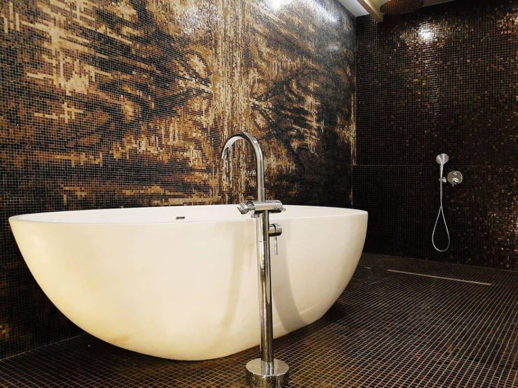 Marbled abstract texture with swirling dark brown and black pigments on a surface.