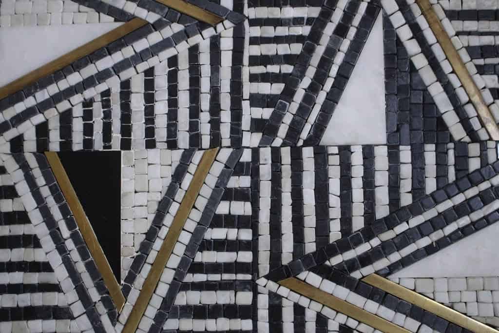 black white marble stone mosaic pattern with brushed brass close-up