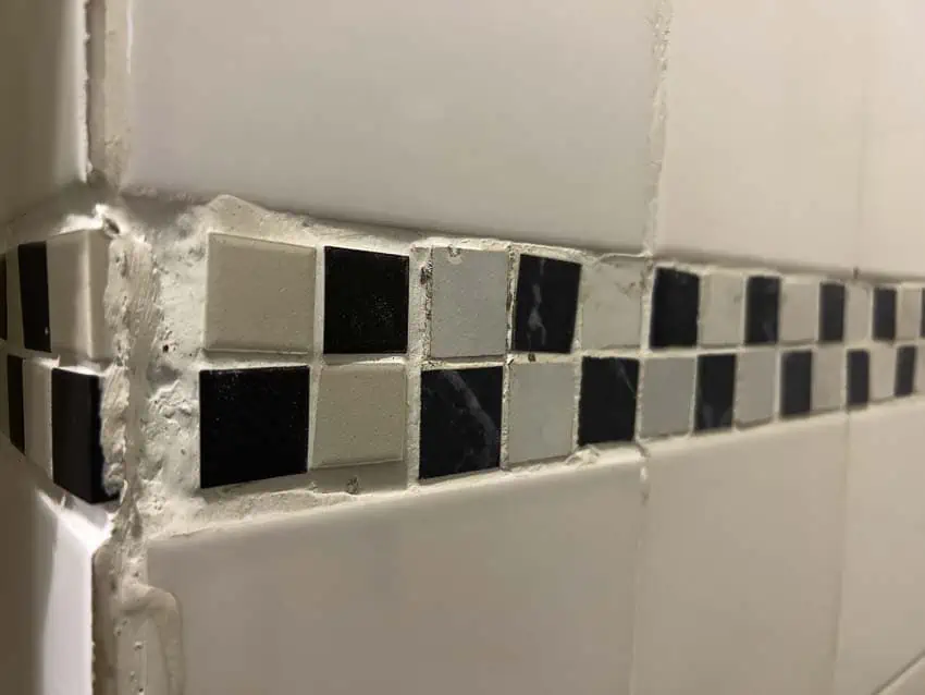 black and white checkered bathroom wall mosaic border with several installation problems