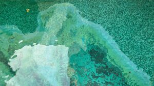 Intricately patterned green mosaic pool tiles create a natural, abstract underwater landscape effect.