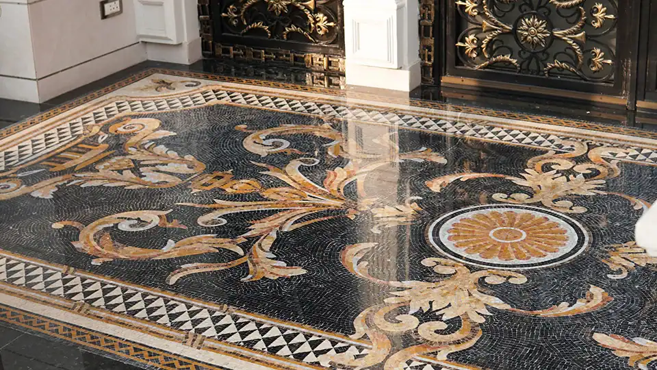 Luxurious mosaic floor design in black and gold tones, handcrafted by MEC Artworks for opulent interiors.