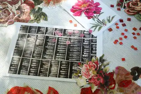 Mosaic design planning sheet surrounded by red tiles and floral references for intricate artistic layout.