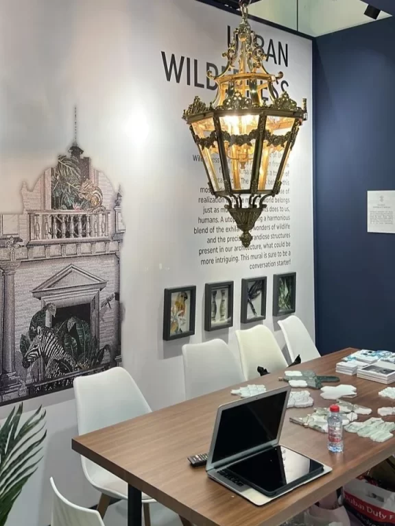 Mosaic mural in modern showroom with chandelier, zebra detail, wall text, and design samples displayed.