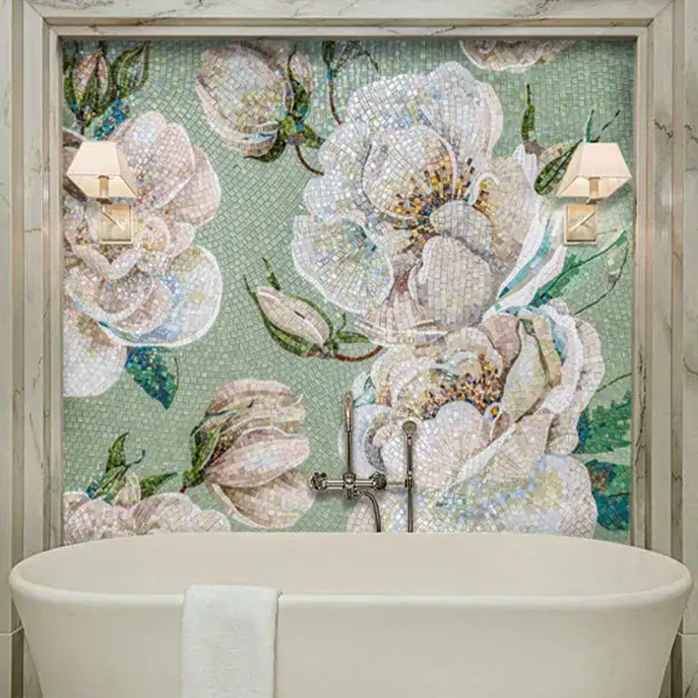 Luxurious bathroom with floral mosaic wall art, soft pastel tones, freestanding tub, and wall lights.