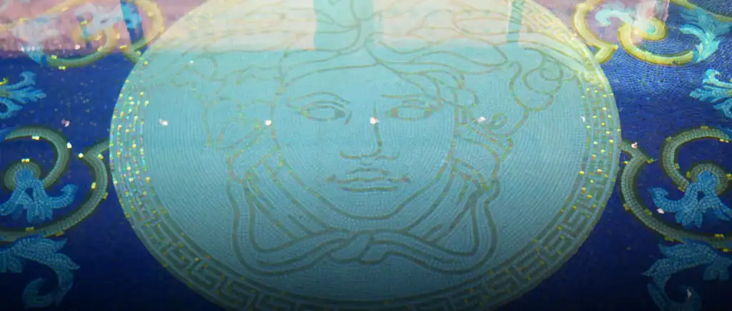 Luxury swimming pool mosaic featuring Versace Medusa head in aqua blue tiles with Greek key border.