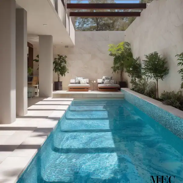 Light aqua mosaic tile swimming pool with blue-green reflective finish, striped sunlight patterns, and modern rectangular design.