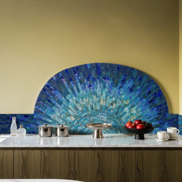 Mosaic kitchen backsplash with radiant fan-shaped design in shades of blue and teal, creating a luxurious and artistic focal point above the counter.