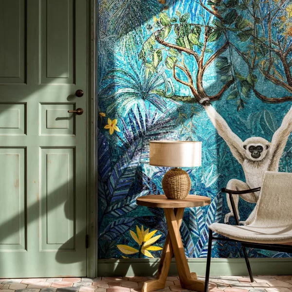 Blue jungle mosaic wall with tropical leaves, branches, yellow flowers, and a white monkey design in detailed handcrafted tile artwork.