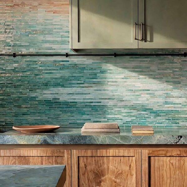 Coastal ombre linear mosaic backsplash with slim horizontal mosaic tiles fading from beige to aqua and deep teal, modern kitchen feature wall design.