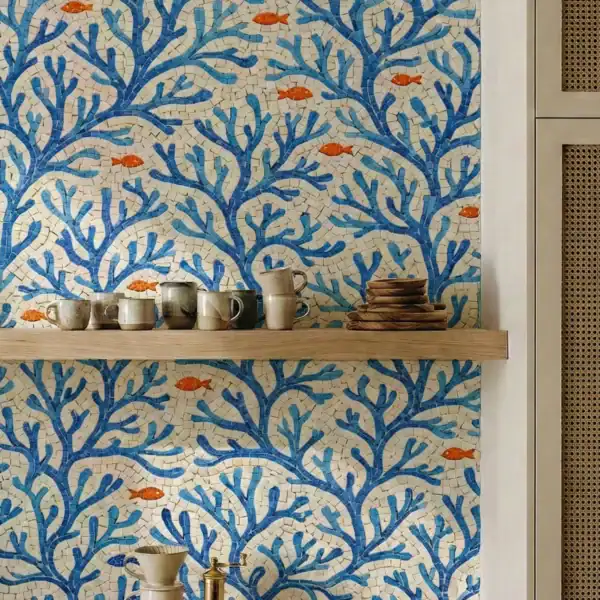 Azure Ivory Reef Mosaic backsplash with blue branching coral pattern and orange fish accents in a coastal kitchen setting.