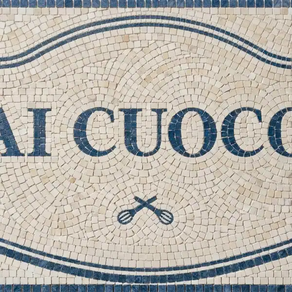 Custom Name Cartouche Mosaic Panel al cuoco mosaic sign with blue lettering and decorative border on ivory stone, ideal for kitchen backsplash, restaurant decor, and culinary spaces
