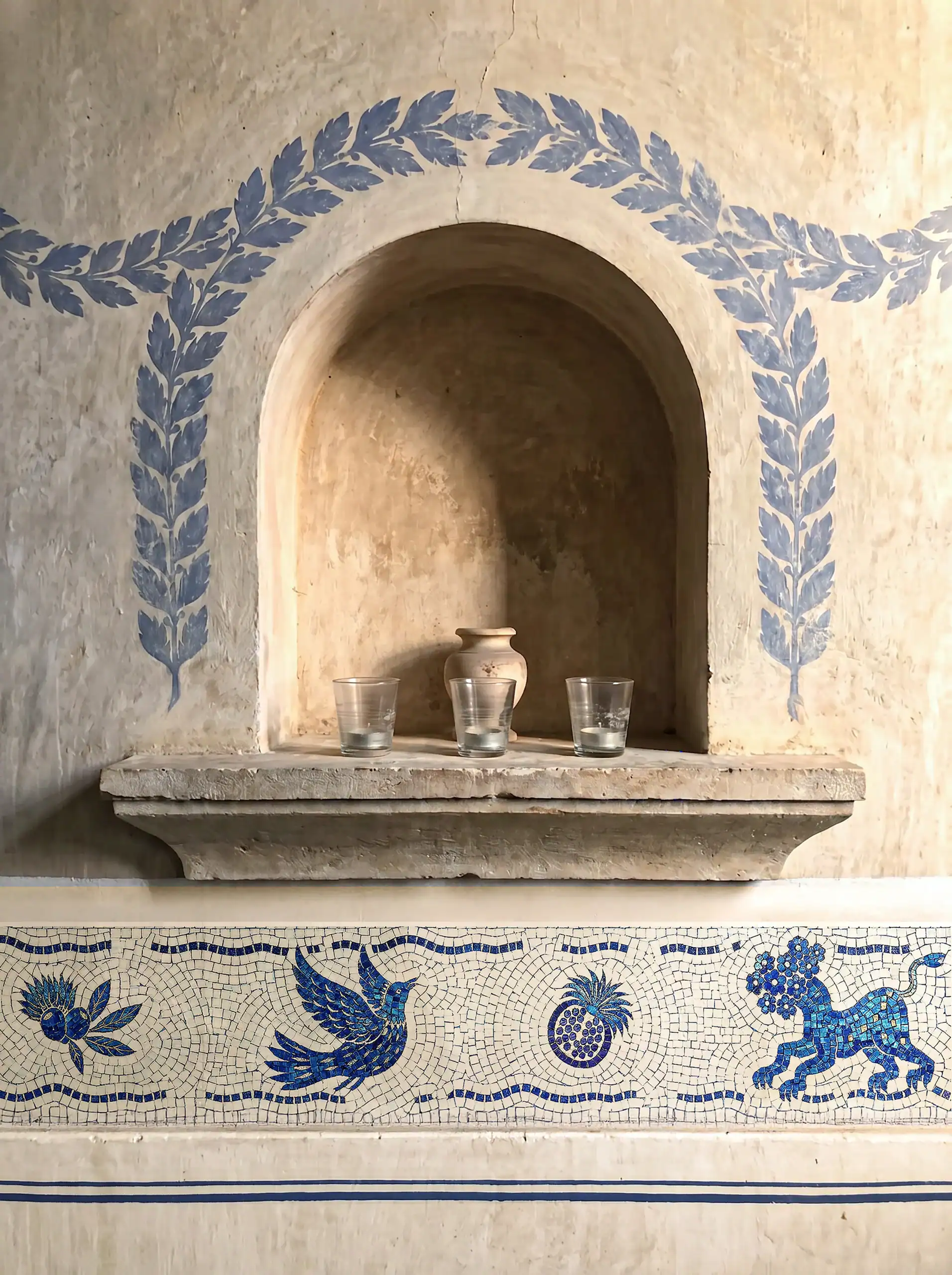 blue and ivory decorative mosaic border with classical motifs and Mediterranean-inspired artistry surrounding a rustic wall niche