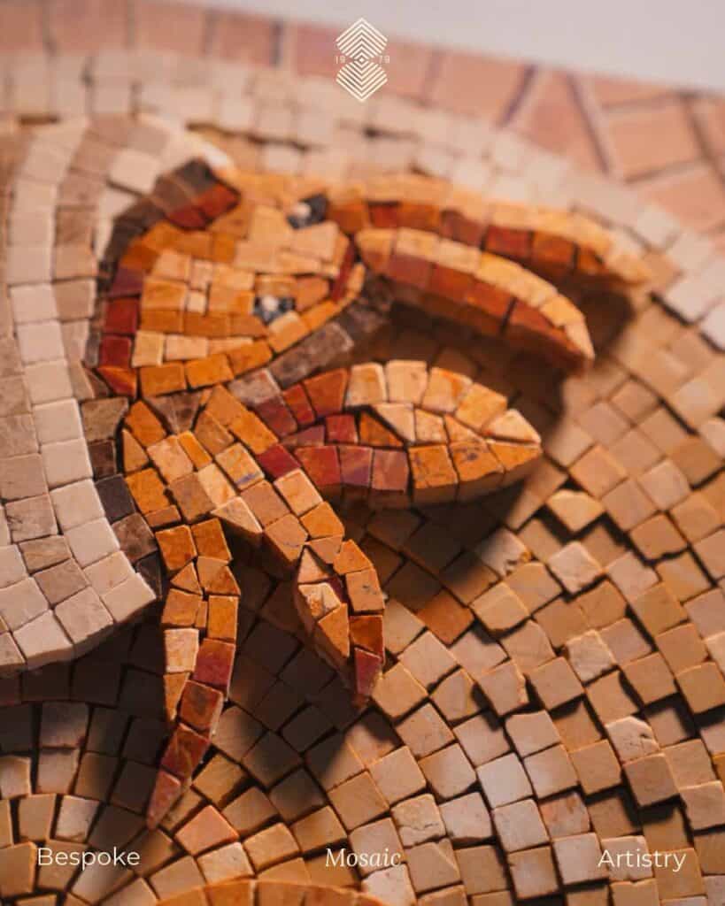 A close-up of an aquatic mosaic art with a warm orange, brown, and beige stone tiles arranged to depict an animal figure.