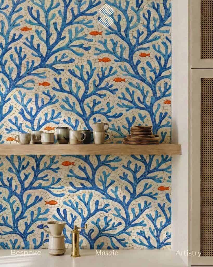 A colorful backsplash with a stunning blue coastal coral branch Mosaic Pattern artwork and orange fishes in a white background adding warmth and contrast.