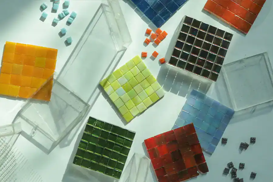 A vibrant multicolor layout of square mosaic pieces in dark green, light green, yellow, deep red and shades of blue