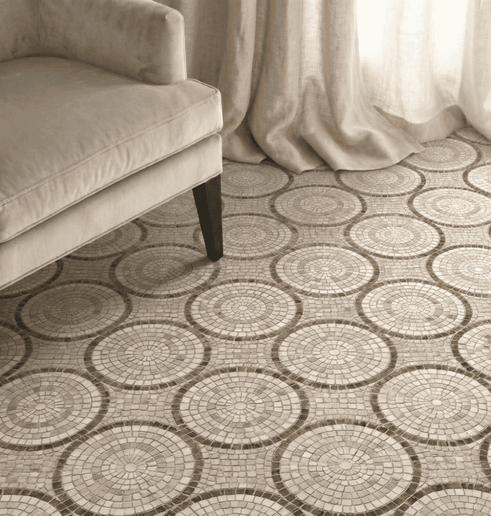 A sophisticated neutral-toned space exhibiting timeless geometric mosaic tile ideas on a stone floor with a repeating concentric circle layout in beige and cream.