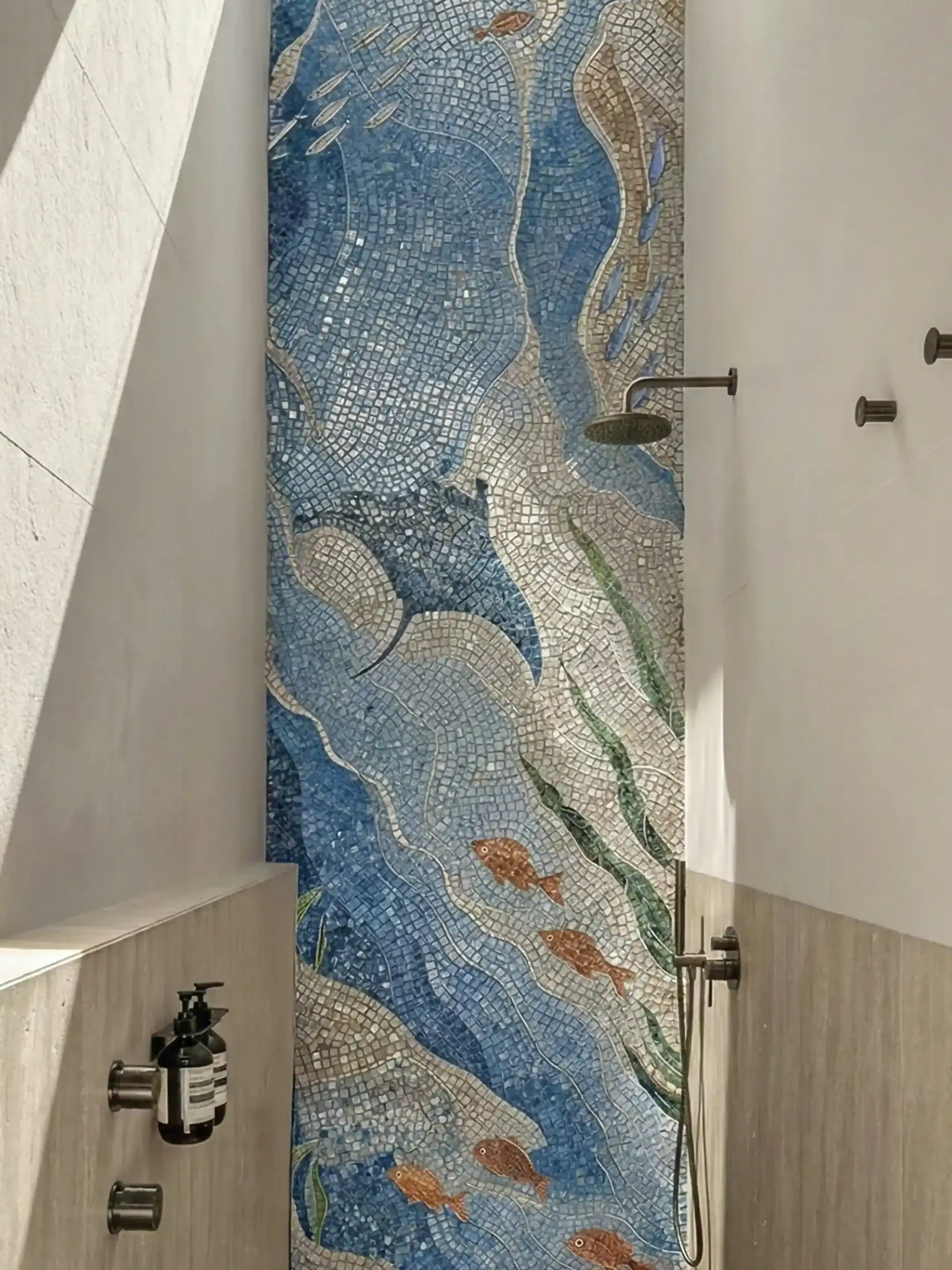 A very delicate custom ocean mosaic artwork with deep cobalt, sky blue, sand, and muted seaweed green tones, with orange fish