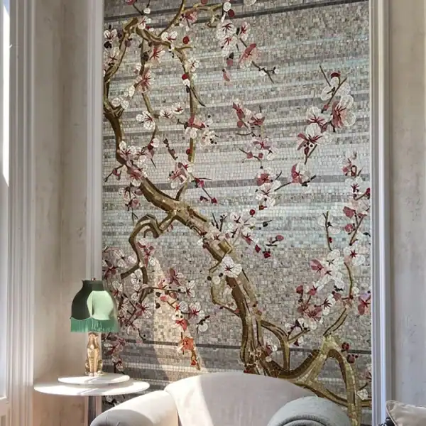 The Sakura Branch The Sakura Branch Mosaic features delicate white and blush blossoms on flowing branches against a layered grey glass and marble mosaic background.