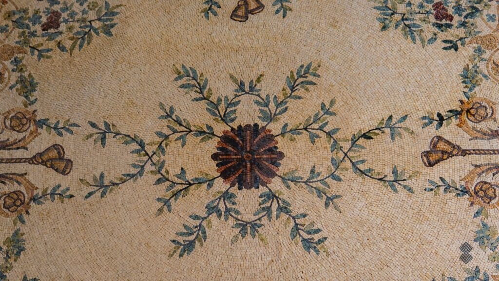 A marble mosaic rug sporting an intricate leaf and flower design