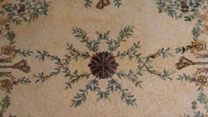 A marble mosaic rug sporting an intricate leaf and flower design