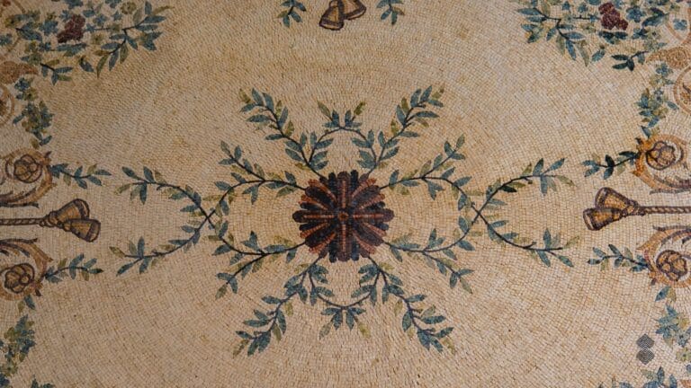 A marble mosaic rug sporting an intricate leaf and flower design