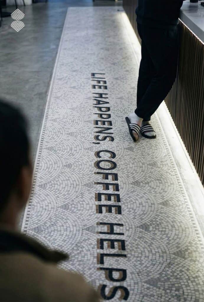 Custom mosaic floor design creating a decorative entrance for a modern café