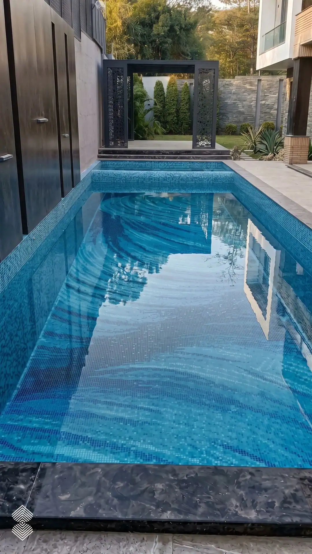 Lumina Obscura Mosaic features flowing aqua, turquoise and deep blue glass mosaic bands across a luxury contemporary swimming pool.