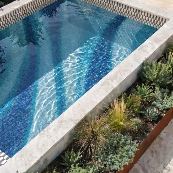 The Equinox The Equinox Mosaic features layered aqua, turquoise and deep blue glass mosaic bands creating a contemporary design across a luxury swimming pool.