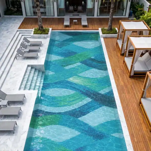 Verre Céleste Verre Céleste Mosaic features flowing turquoise, blue, green and white glass mosaic forms across a luxury swimming pool with an abstract design.