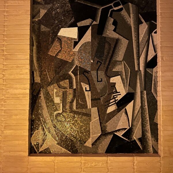 Cubist Fragmented Figure Mosaic Panel A cubist mosaic wall art panel of fractured gray and gold tesserae set into a restaurant wall niche.