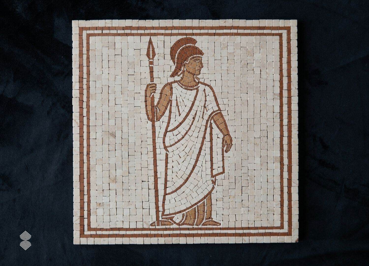 A roman soldier wall mosaic showing a helmeted figure holding a spear, set in cream stone tesserae with a rust-brown border.