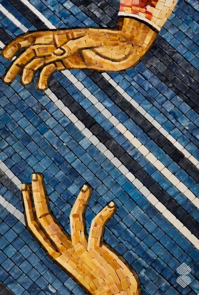 Close-up of Annunciation mosaic highlighting angel Gabriel's raised hand gesture toward the Virgin Mary, crafted with detailed hand-cut tesserae.