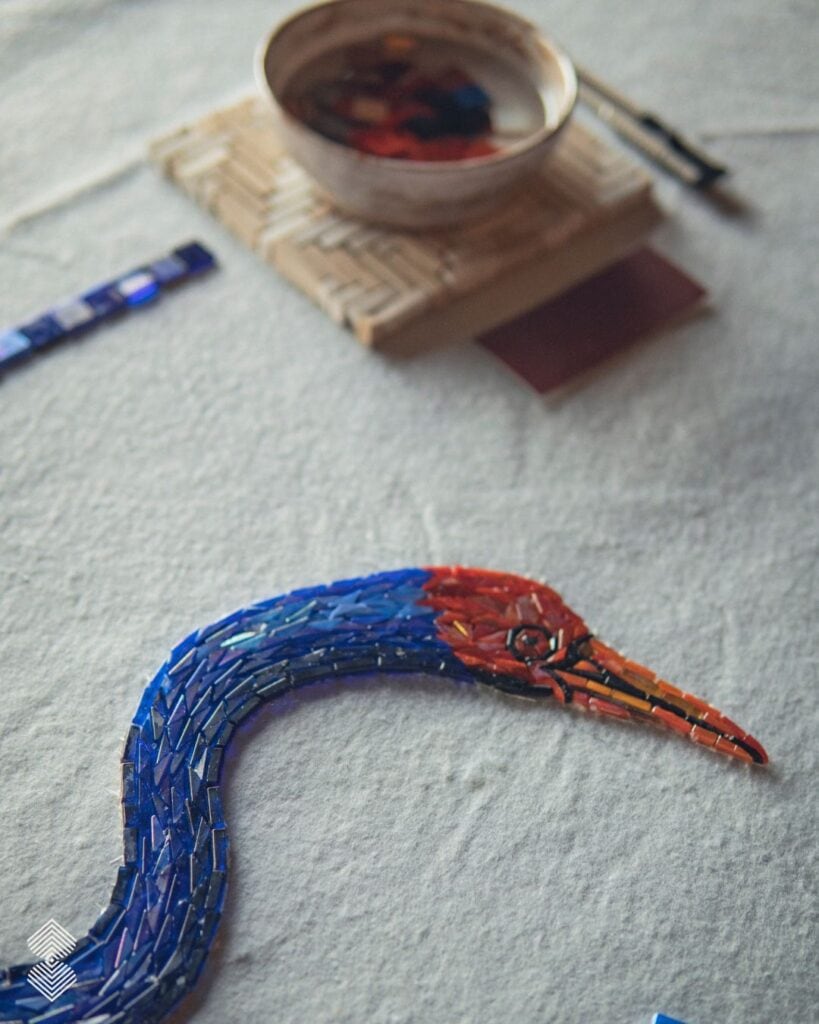 Mosaic artist arranging colorful glass tesserae to create a decorative wall mural
