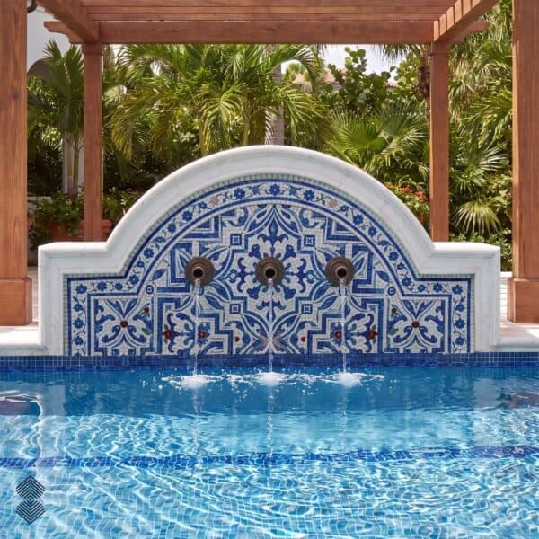 Arched Moroccan Mosaic Wall Fountain Arched Moroccan mosaic fountain with blue and white geometric pattern and three water spouts over a pool