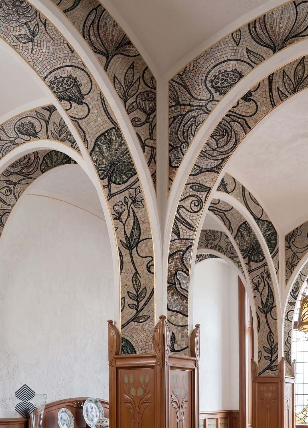 An art nouveau arch mosaic of stylized flowers and leaves covering a groin vault and its arches.