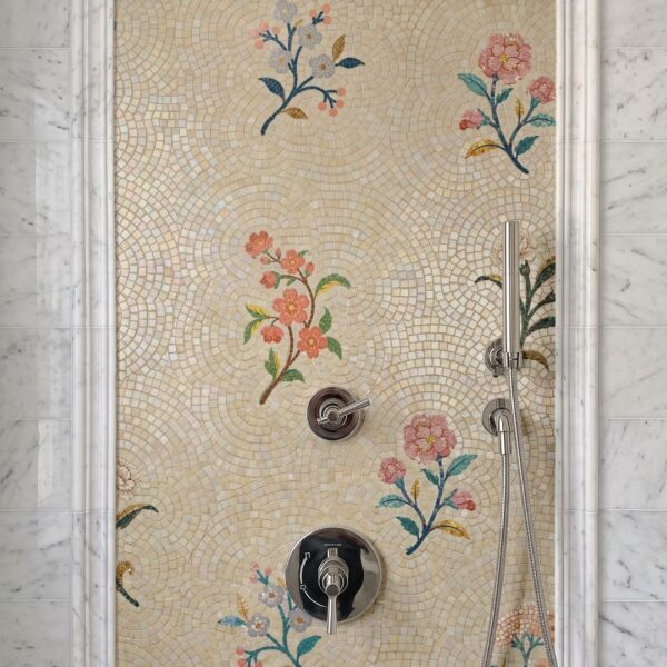 A floral sprig mosaic tile panel with pink and blue blossoms installed as a framed shower wall accent.