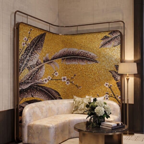 A golden banana leaf mosaic mural with dark bronze leaf forms and pink blossom branches set in glass tesserae on a curved feature wall.
