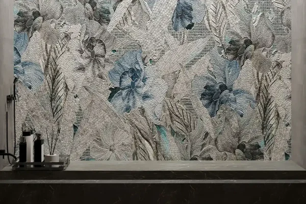 Monochrome floral mosaic wall in modern bathroom with sleek black counter and minimalist soap dispensers.
